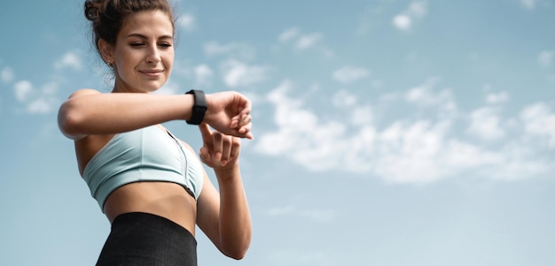 Portrait féminin athlète utilise une montre d'entraînement en plein air de mesure du pouls Fitness Cardio