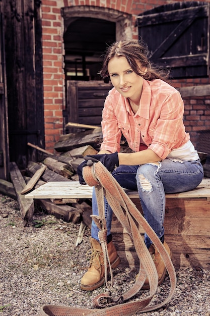 Photo portrait d'une femme adulte assise sur un banc contre un bâtiment