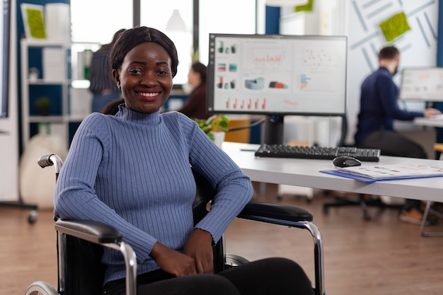 Portrait de femme d'affaires afro-américaine paralysée handicapée souriante en fauteuil roulant