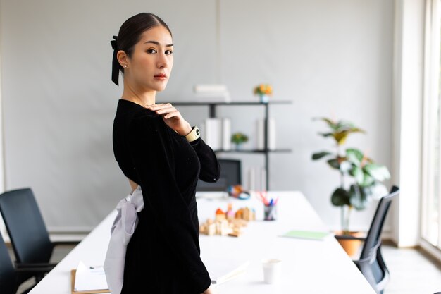 Portrait de femme d'affaires asiatique debout et regardant la caméra dans un bureau à domicile moderne.