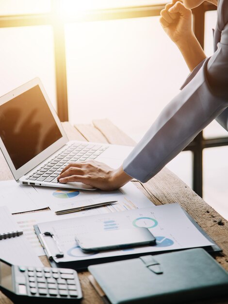 Portrait d'une femme d'affaires asiatique gaie assise à la table au bureau