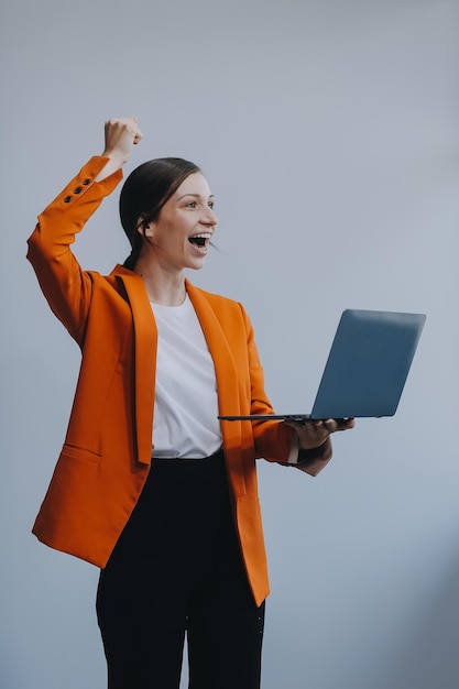 Portrait d'une femme d'affaires asiatique heureuse travaillant sur un ordinateur portable isolé sur un fond blanc
