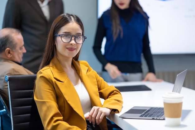 Photo portrait d'une femme d'affaires asiatique regardant une caméra lors d'une réunion du conseil d'administration.