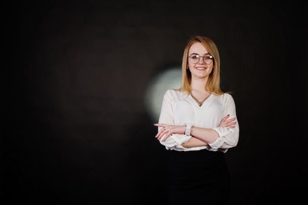 Portrait de femme d'affaires blonde à lunettes, chemisier blanc et jupe noire contre. Femme réussie et concept de fille élégante.