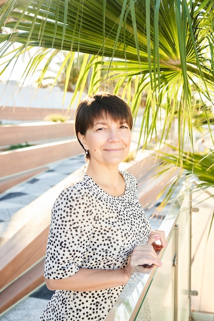 Portrait de femme d'affaires caucasienne heureuse de 50 ans posant et souriant dans le parc, adulte en bonne santé vraie dame