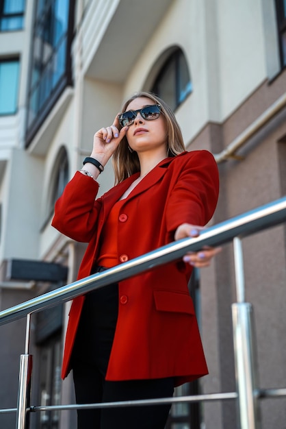 Portrait de femme d'affaires en costume debout près d'un immeuble de bureaux avec elle