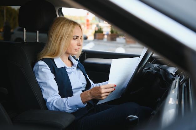 Portrait de femme d'affaires élégante d'âge moyen en voiture