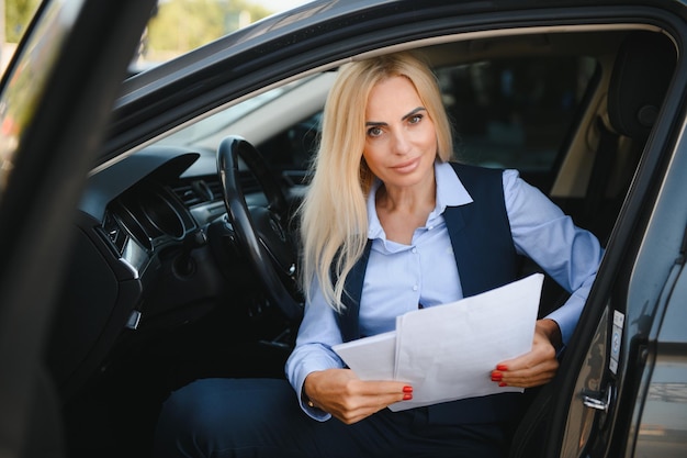 Portrait de femme d'affaires élégante d'âge moyen en voiture