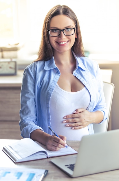 Portrait de femme d'affaires enceinte belle à lunettes.