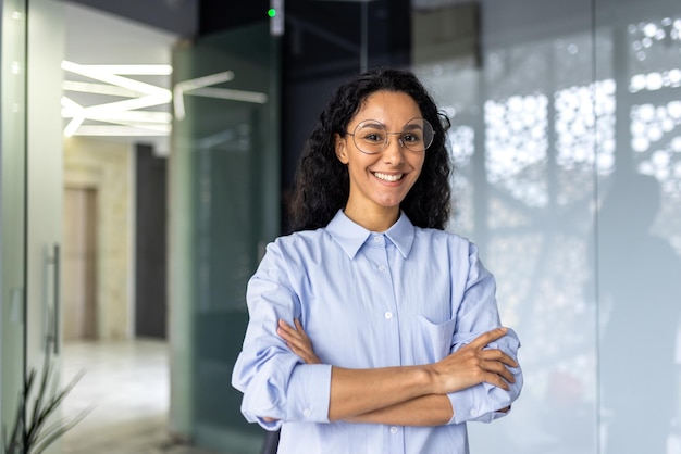 Portrait d'une femme d'affaires heureuse et réussie patronne en chemise souriant et regardant la caméra à l'intérieur