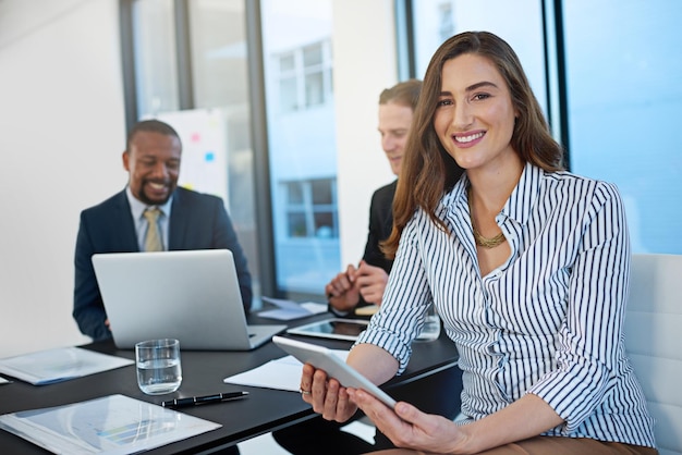 Portrait d'une femme d'affaires heureuse sur une tablette dans un bureau réunion pour le leadership coworking et à notre sujet Face conseiller financier et entrepreneur sur la technologie numérique employé et gestionnaire avec équipe de travail