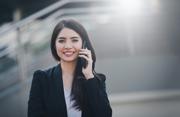 Portrait de femme d&#39;affaires heureux sourire parler sur smartphone