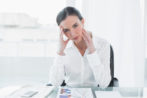 Portrait de femme d&#39;affaires inquiet avec des graphiques au bureau