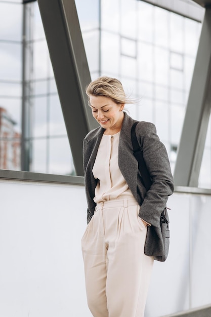 Portrait d'une femme d'affaires mature souriant avec émotions sur le fond urbain moderne