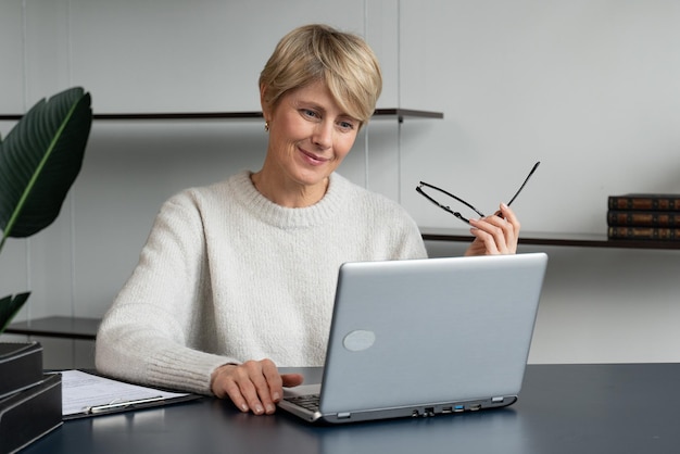 Portrait d'une femme d'affaires mature travaillant sur un ordinateur portable sur le lieu de travail au bureau l'enlève