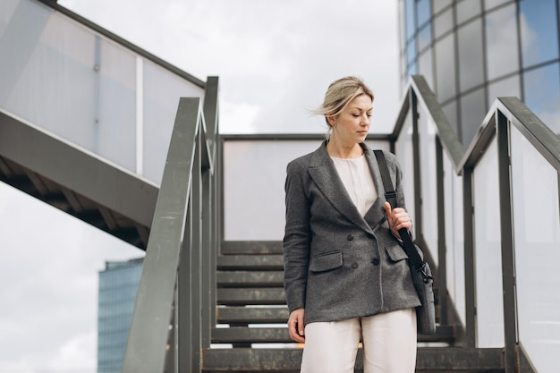 Portrait d'une femme d'affaires mûre sur un bureau moderne et un arrière-plan urbain