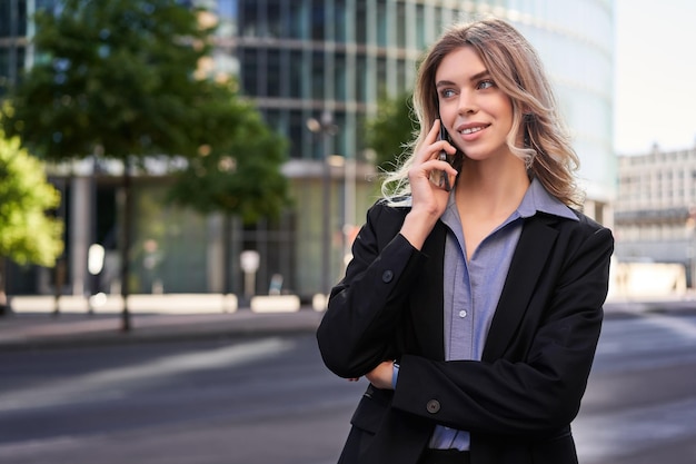 Portrait d'une femme d'affaires prospère, PDG d'une entreprise, marche dans la rue et passe des appels téléphoniques en parlant sur sm