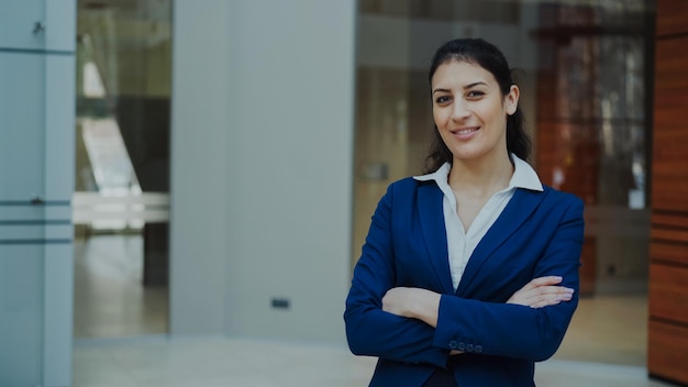 Portrait d'une femme d'affaires prospère souriante et regardant dans la caméra dans un bureau moderne