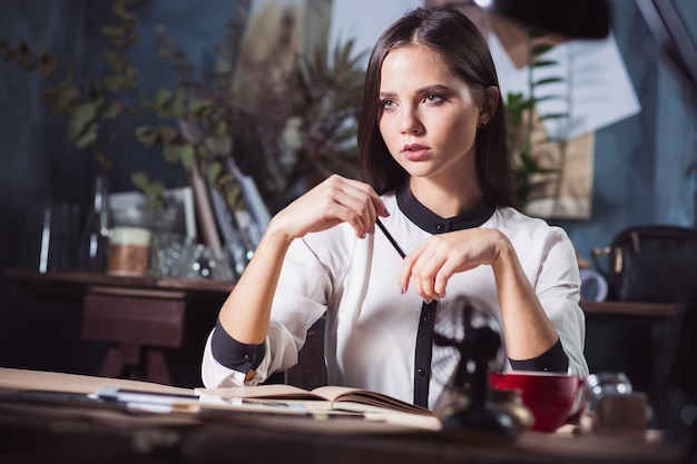 Portrait d'une femme d'affaires qui travaille au bureau et vérifie les détails de sa prochaine réunion dans son cahier et travaille au loft studio