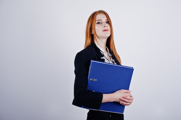 Portrait d'une femme d'affaires rousse vêtue d'une blouse à rayures et d'une veste avec une chemise bleue.