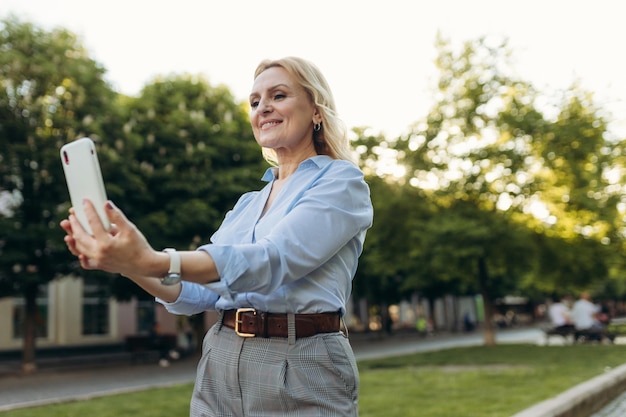 Portrait d'une femme d'affaires senior utilisant un smartphone dans la ville