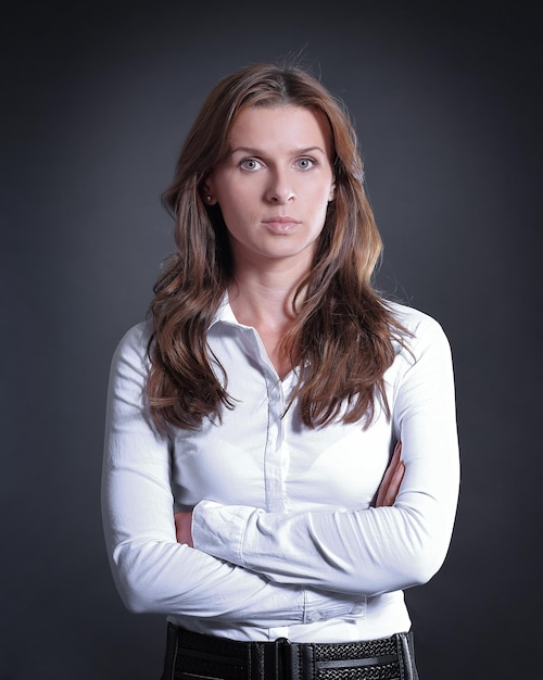 Portrait de femme d'affaires sérieuse sur fond sombre