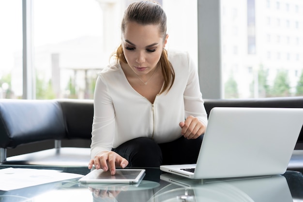 Portrait d'une femme d'affaires sérieuse utilisant un ordinateur portable au bureau.