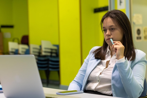 Portrait d'une femme d'affaires à son poste de travail au bureau devant son concepteur d'ordinateur pensant à la solution à ses problèmes