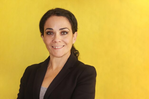 Photo portrait d'une femme d'affaires souriante sur un fond jaune