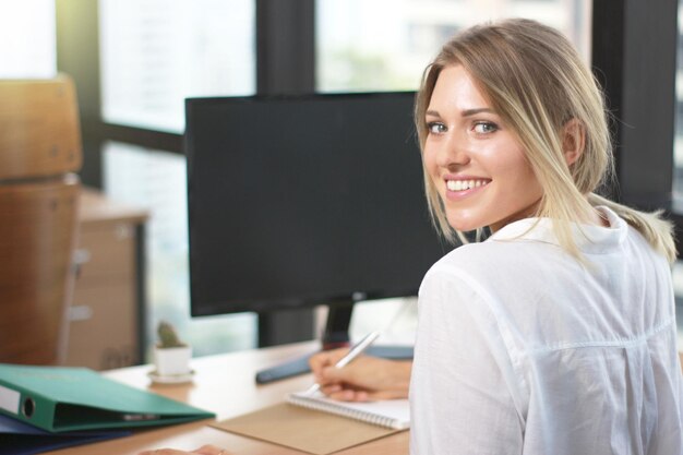 Portrait d'une femme d'affaires travaillant avec un stylo à la main dans un immeuble de bureaux moderne