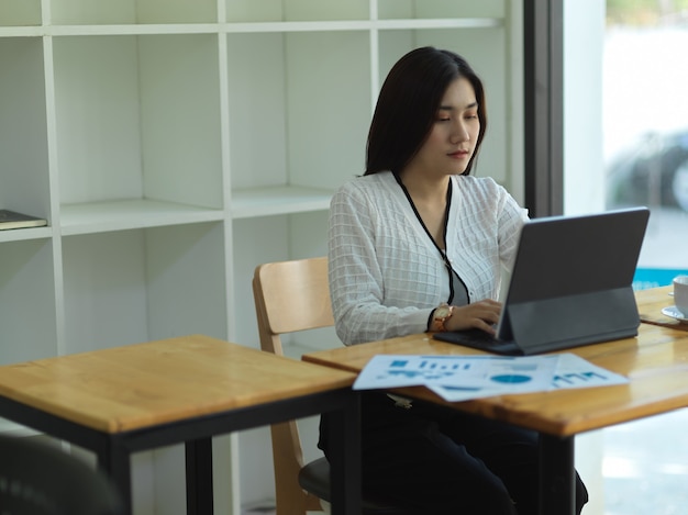 Portrait De Femme D'affaires Travaillant Avec Tablette Numérique Et Document Commercial Sur Table En Bois