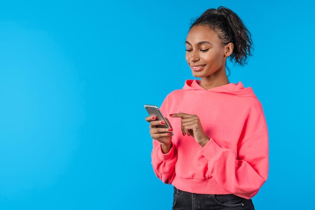 Portrait d'une femme africaine souriante avec un téléphone intelligent dans les mains