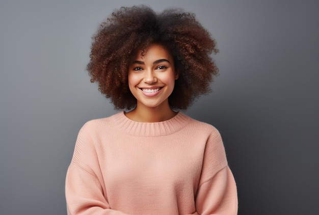 portrait d'une femme afro-américaine aux cheveux bouclés portant un pull de couleur pêche