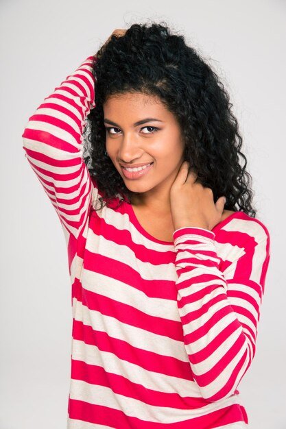 Portrait d'une femme afro-américaine souriante posant isolé sur un mur blanc