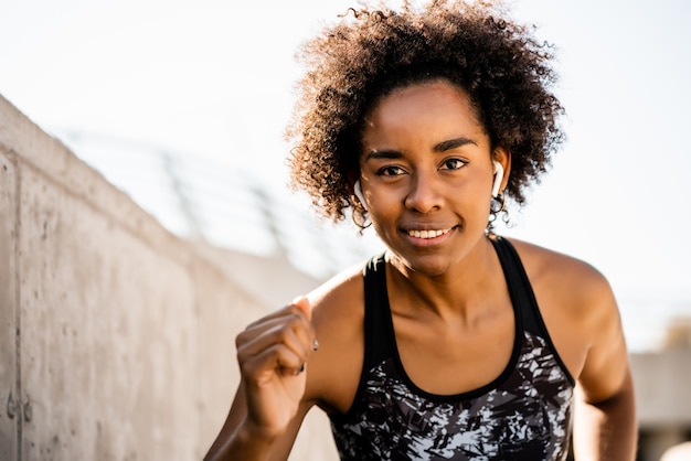 Portrait d'une femme afro-athlète qui court et fait de l'exercice à l'extérieur. Sport et mode de vie sain.