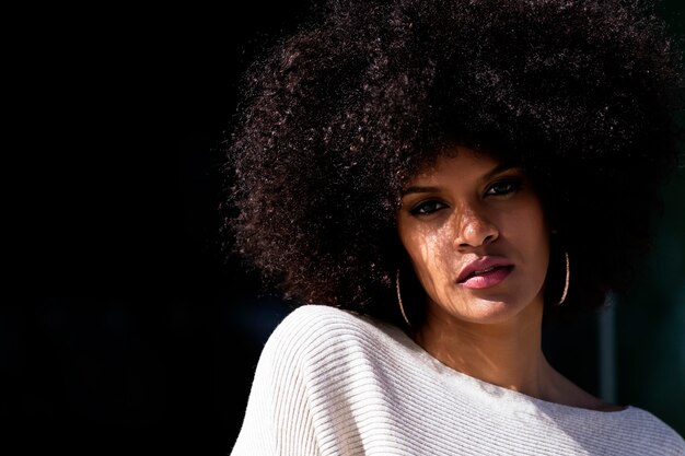 Portrait d'une femme afro séduisante au-dessus du mur. Notion de coiffure