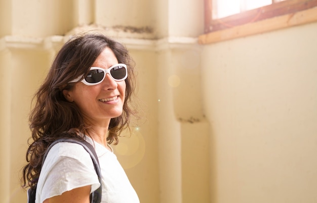 Portrait d'une femme d'âge moyen portant des lunettes de soleil. Espoir, bonheur, lumière