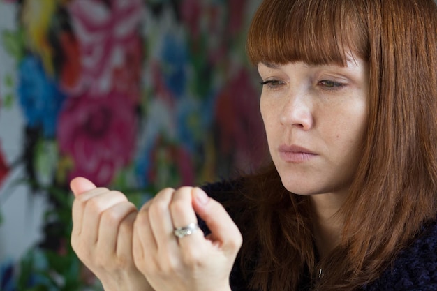 Photo portrait de la femme d'âge moyen regardant ses ongles mécontent