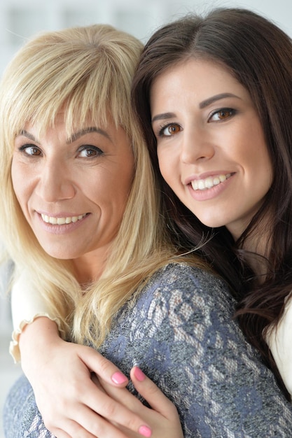 Portrait de femme d'âge moyen avec sa fille serrant à la maison