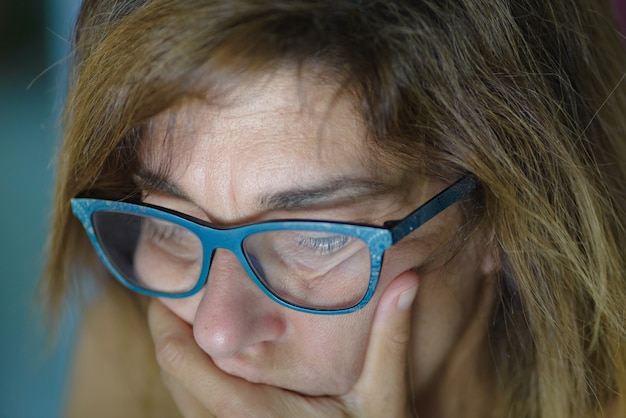 Portrait de femme d&#39;âge mûr stressée avec la main sur la bouche, regardant vers le bas