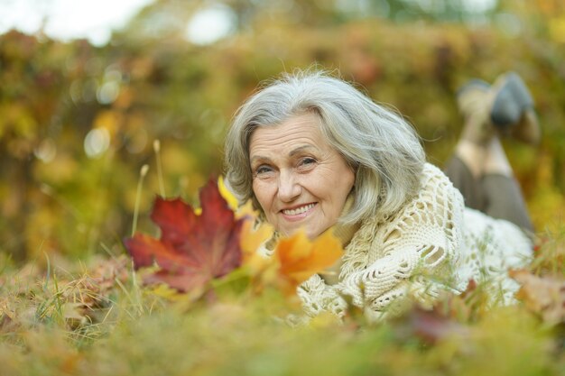 Portrait d'une femme âgée allongée sur les feuilles