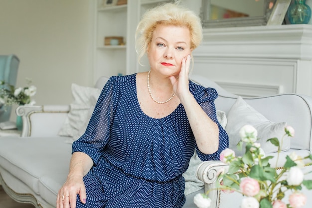 Portrait d'une femme âgée blonde à la maison de 60 ans