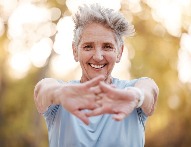 Portrait femme âgée et étirement des mains en plein air et exercice pour la santé et la forme physique à la retraite