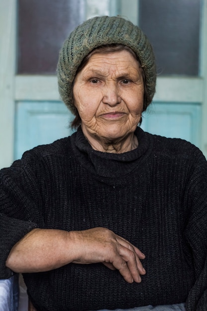 Portrait d&#39;une femme âgée. Une grand-mère réfléchie est assise dans une pièce.