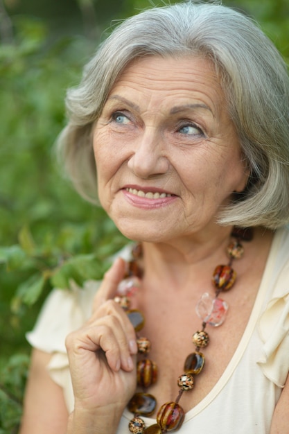 Portrait d'une femme âgée heureuse dans le parc d'automne