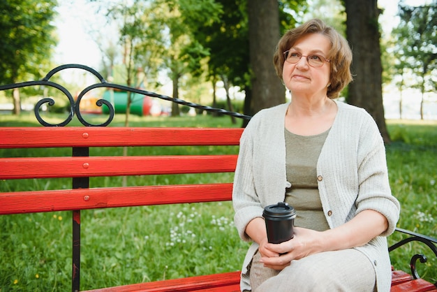 Portrait d'une femme âgée heureuse dans un parc d'été