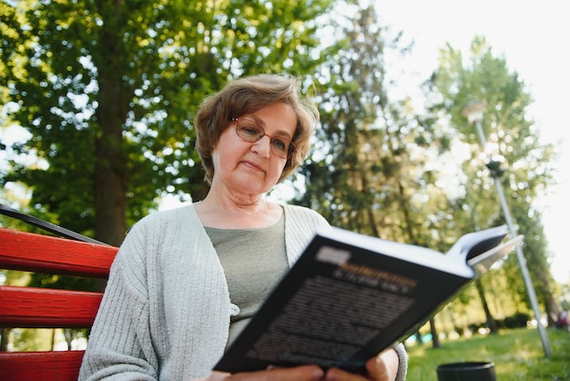 Portrait d'une femme âgée heureuse dans un parc d'été