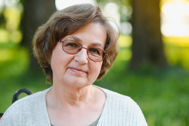 Portrait d'une femme âgée heureuse dans un parc d'été