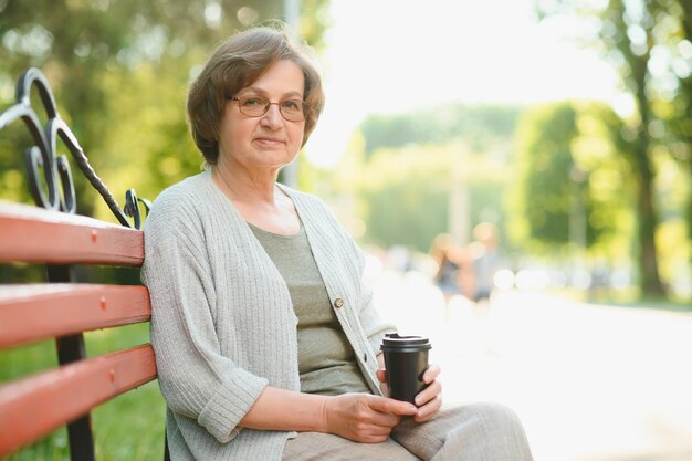 Portrait d'une femme âgée heureuse dans un parc d'été