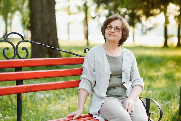 Portrait d'une femme âgée heureuse dans un parc d'été